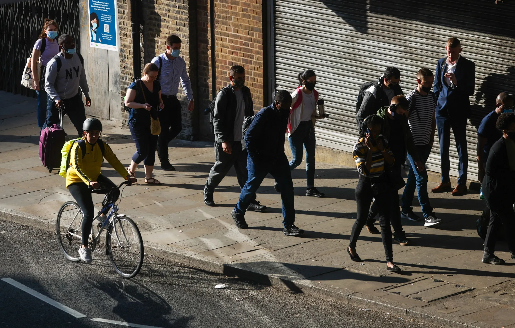 Commuters walk past a railway station in London.&nbsp;