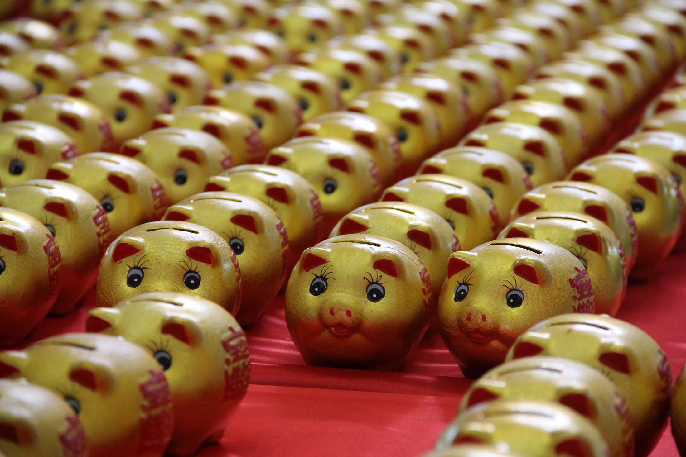 BINZHOU, CHINA - JANUARY 01: (CHINA OUT) Golden piggy banks pose the '2016' at a furniture market for lottery to celebrate new year on January 1, 2016 in Binzhou, Shandong Province of China. Citizens who purchase commodities from the furniture market will get a lottery chance and lucky men will gain a golden piggy bank.
