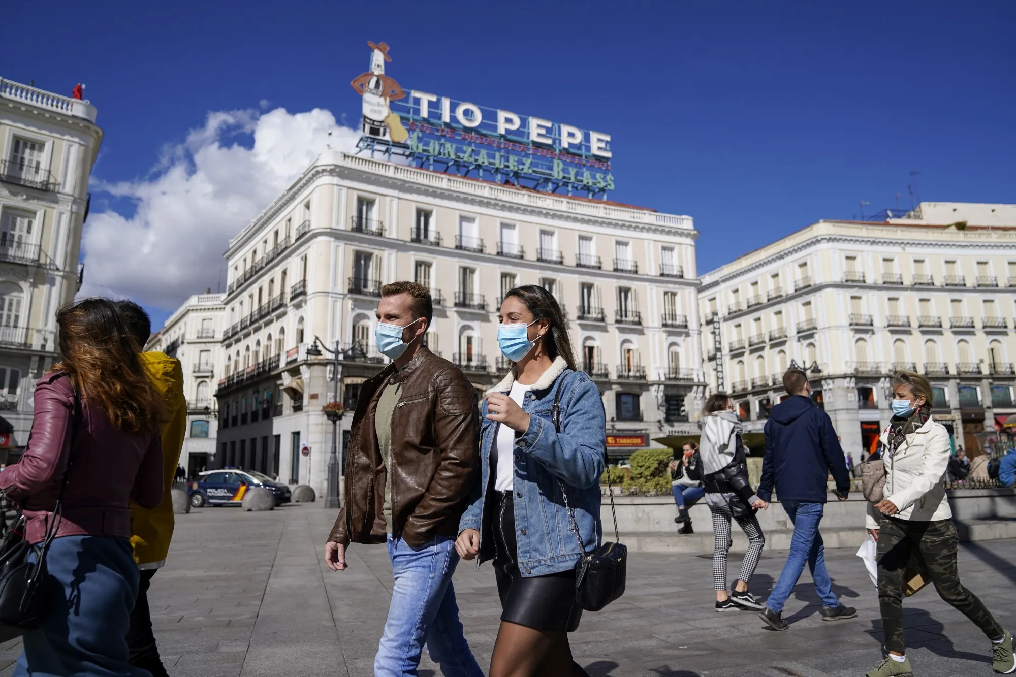 Pedestrians wearing protective masks walk through Puerta del Sol square in Madrid, Spain, on&nbsp;Oct. 2.