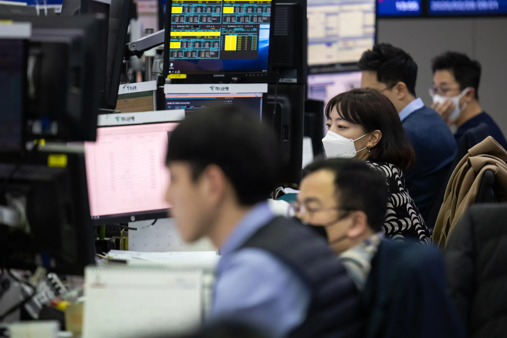 Foreign currency dealers wearing protective masks work in Seoul.