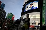 Japan’s Prime Minister Shinzo Abe is seen on a public screen as he announces the lifting of a nationwide state of emergency on May 25.