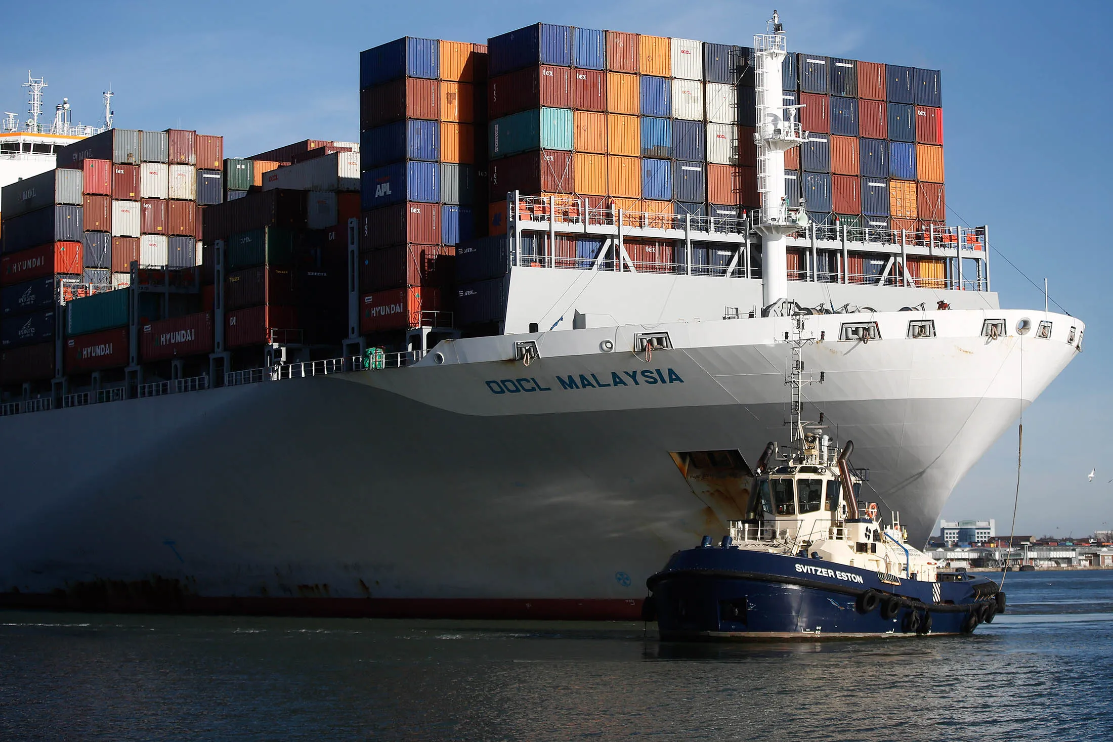 A tugboat guides the Orient Overseas Container Line's Malaysia container ship into the Port of Southampton.
