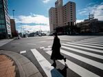A woman wearing a protective mask crosses a street in Tokyo on January 29, 2020.
