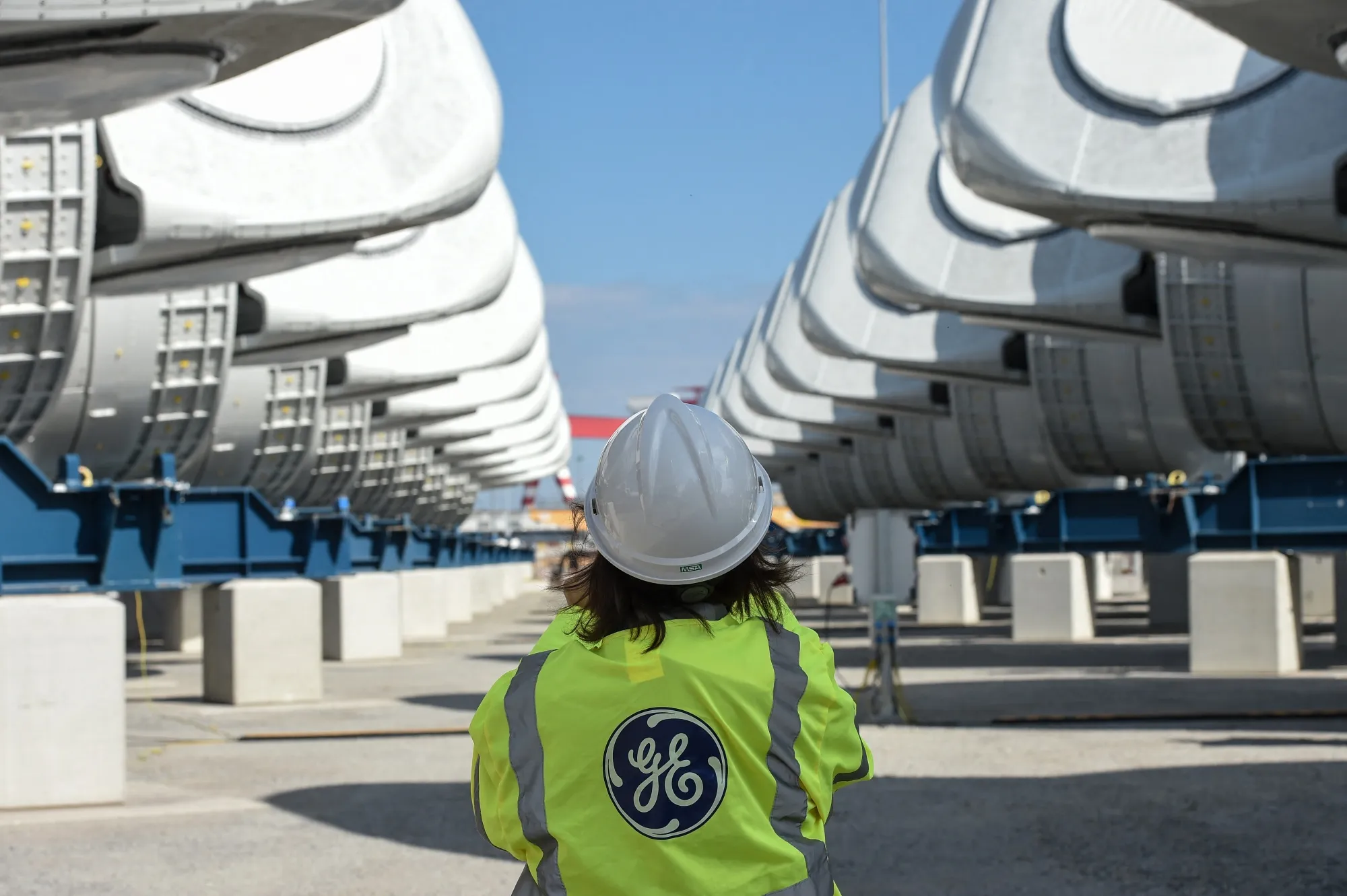 General Electric employee walks between wind turbine nacelles for a wind farm.&nbsp;