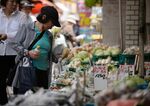 A customer shops for vegetables at a store at the Sunamachi Ginza shopping street in Tokyo.