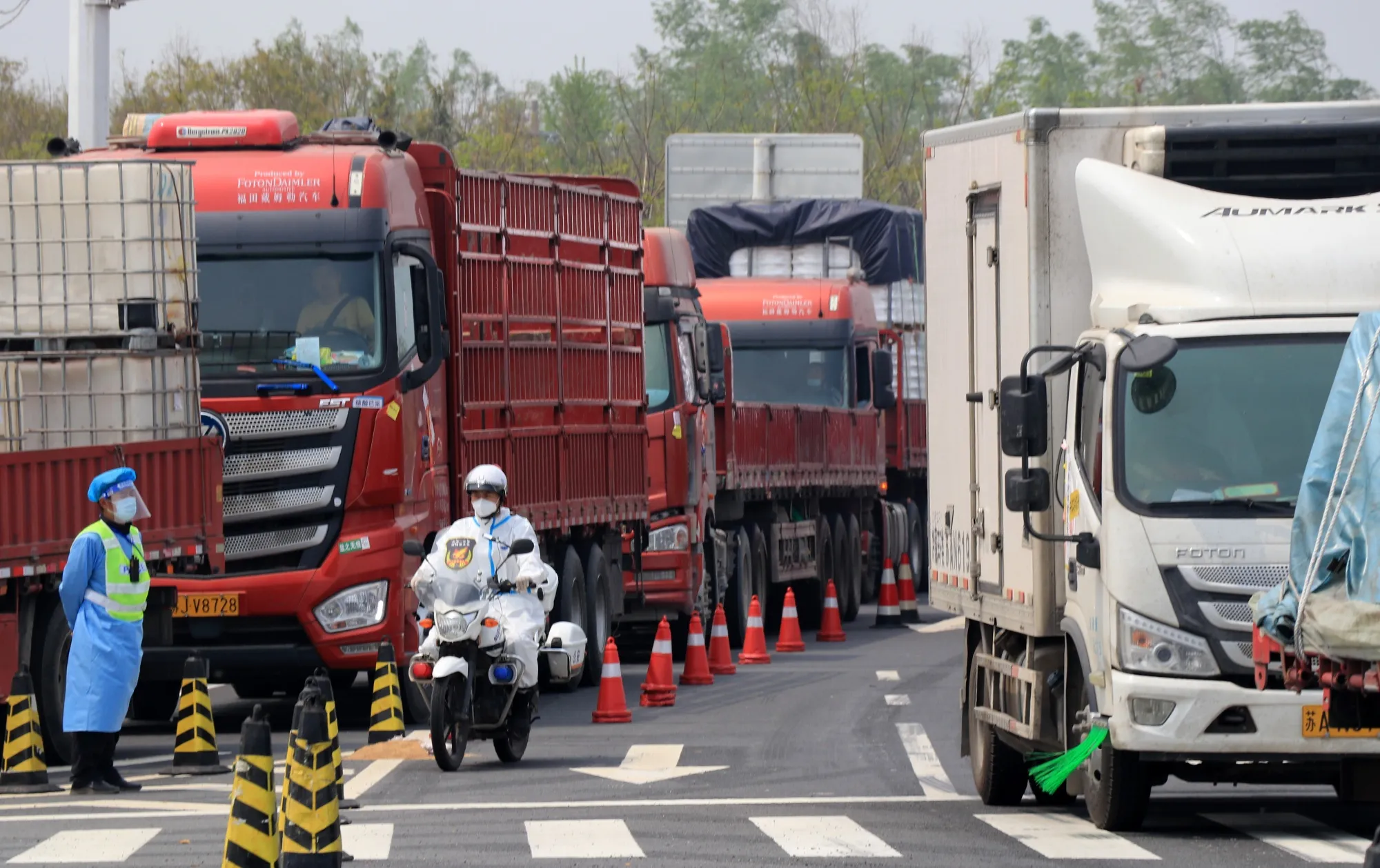 Officials check drivers on the arriving trucks in Yancheng city in Jiangsu province, on April 12.