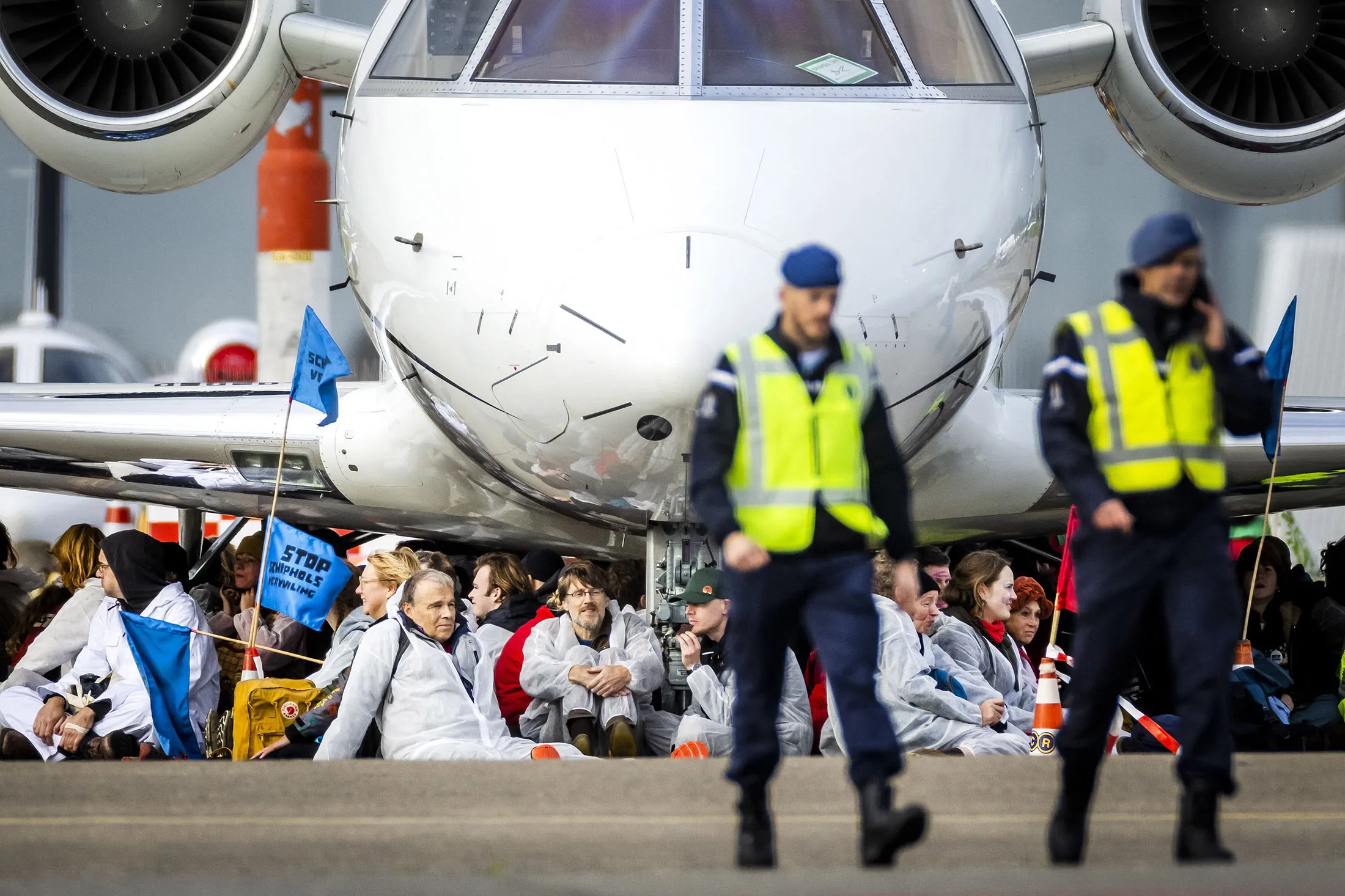 Demonstrators sit in front of an aircraft during a protest at Schiphol Airport, near Amsterdam, Netherlands, on Nov.&nbsp;5.