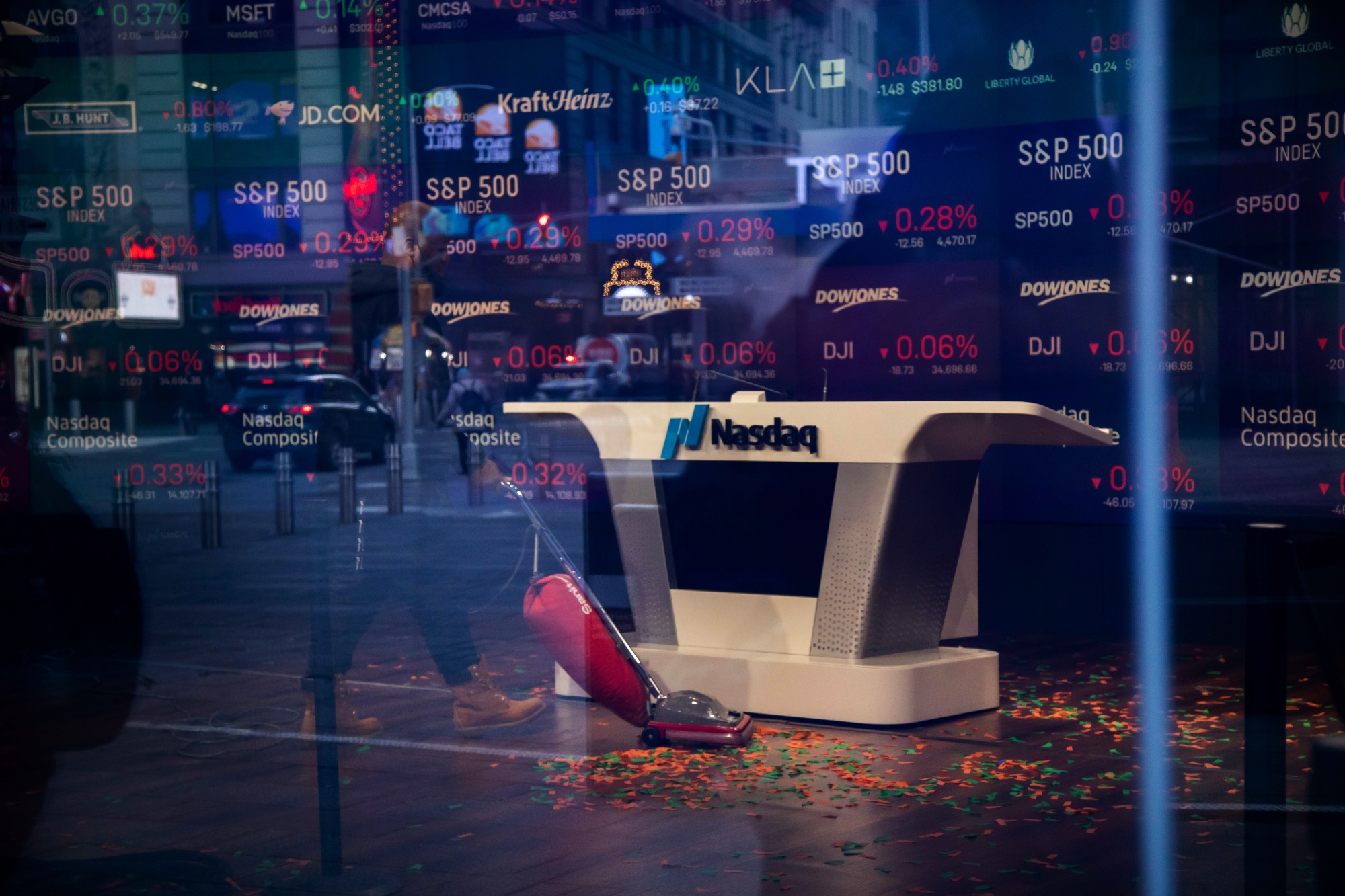 A worker vacuums up confetti after the opening bell at the Nasdaq MarketSite in New York.