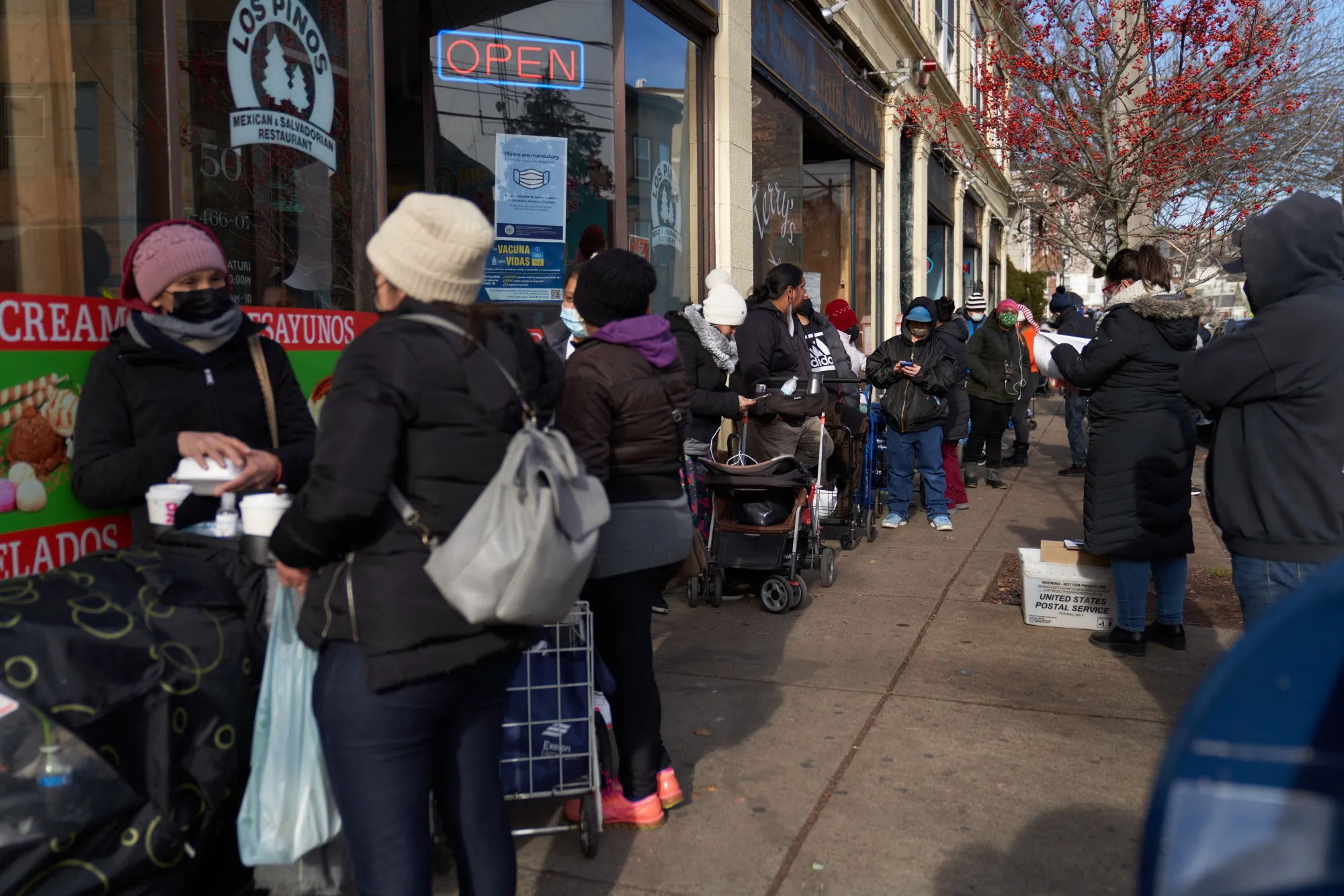 Residents wait to receive free Covid-19 at-home test kits with groceries at a food distribution site in Chelsea, Massachusetts, on Dec. 21.