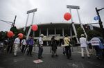 Protesters march at Tokyo's old National Stadium, which will be demolished and replaced with a new National Stadium.