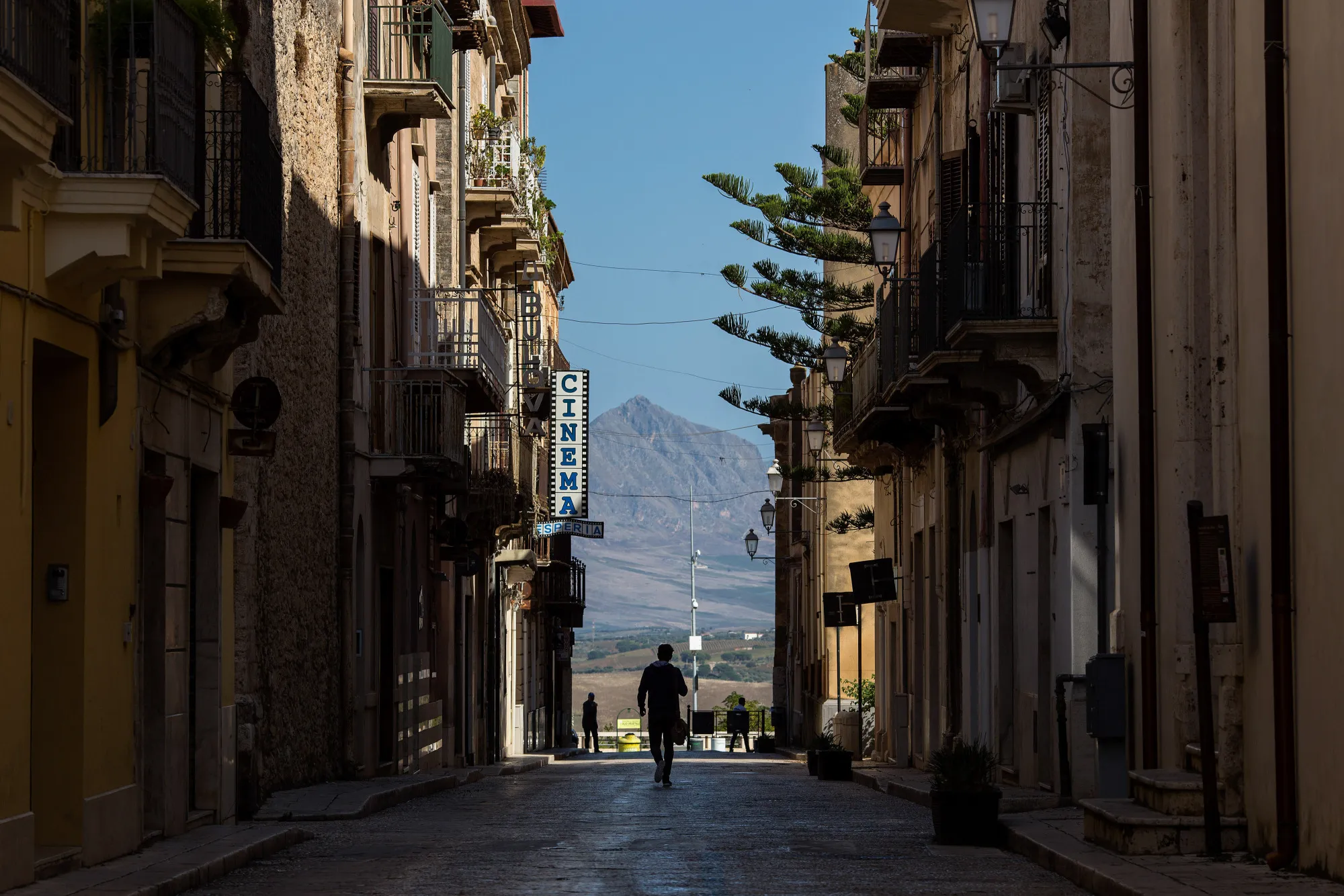 A pedestrian walks along a road in Sicily, Italy
