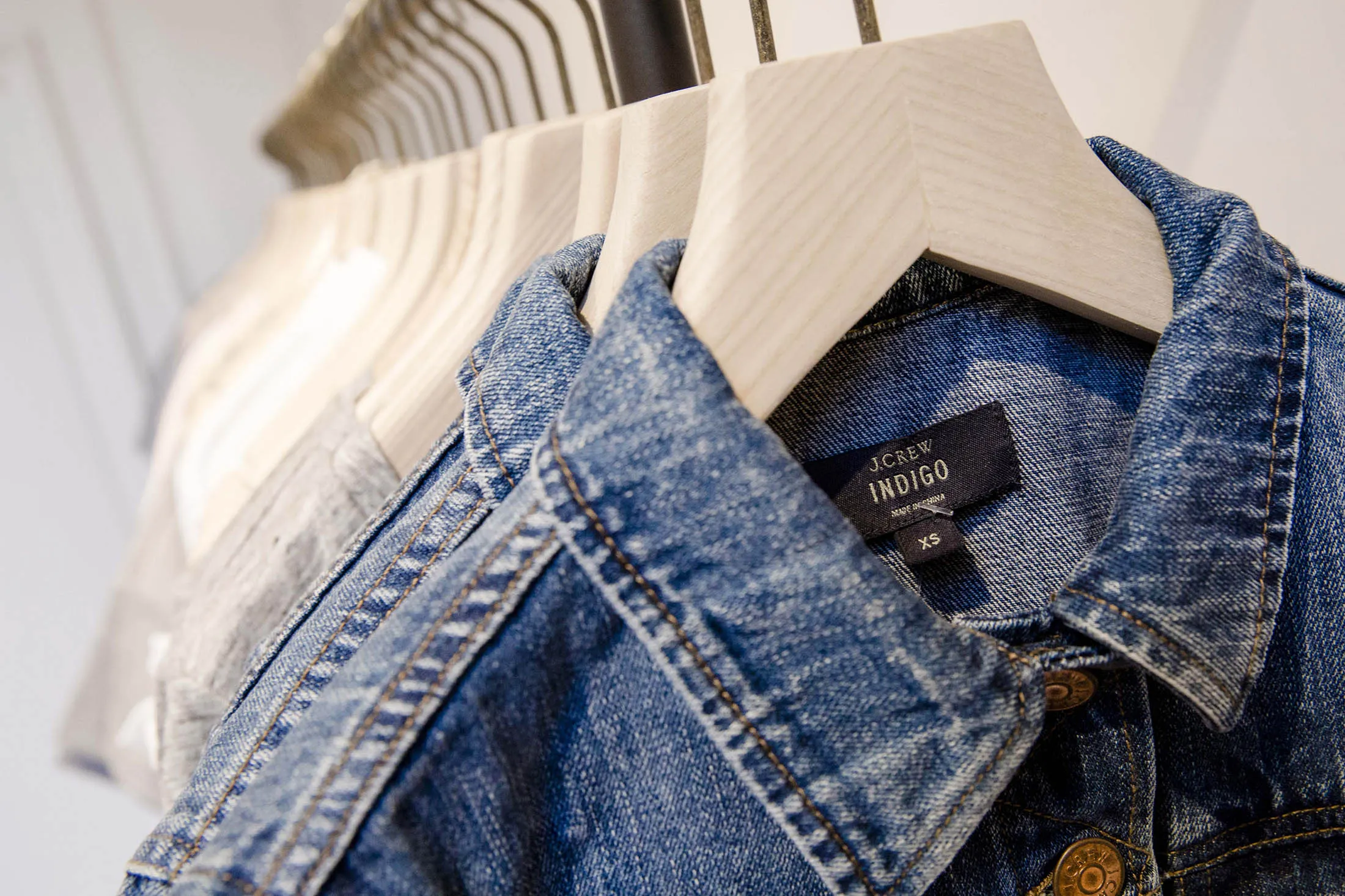 Denim jackets sit on hangers inside a J. Crew Group Inc. fashion store.
