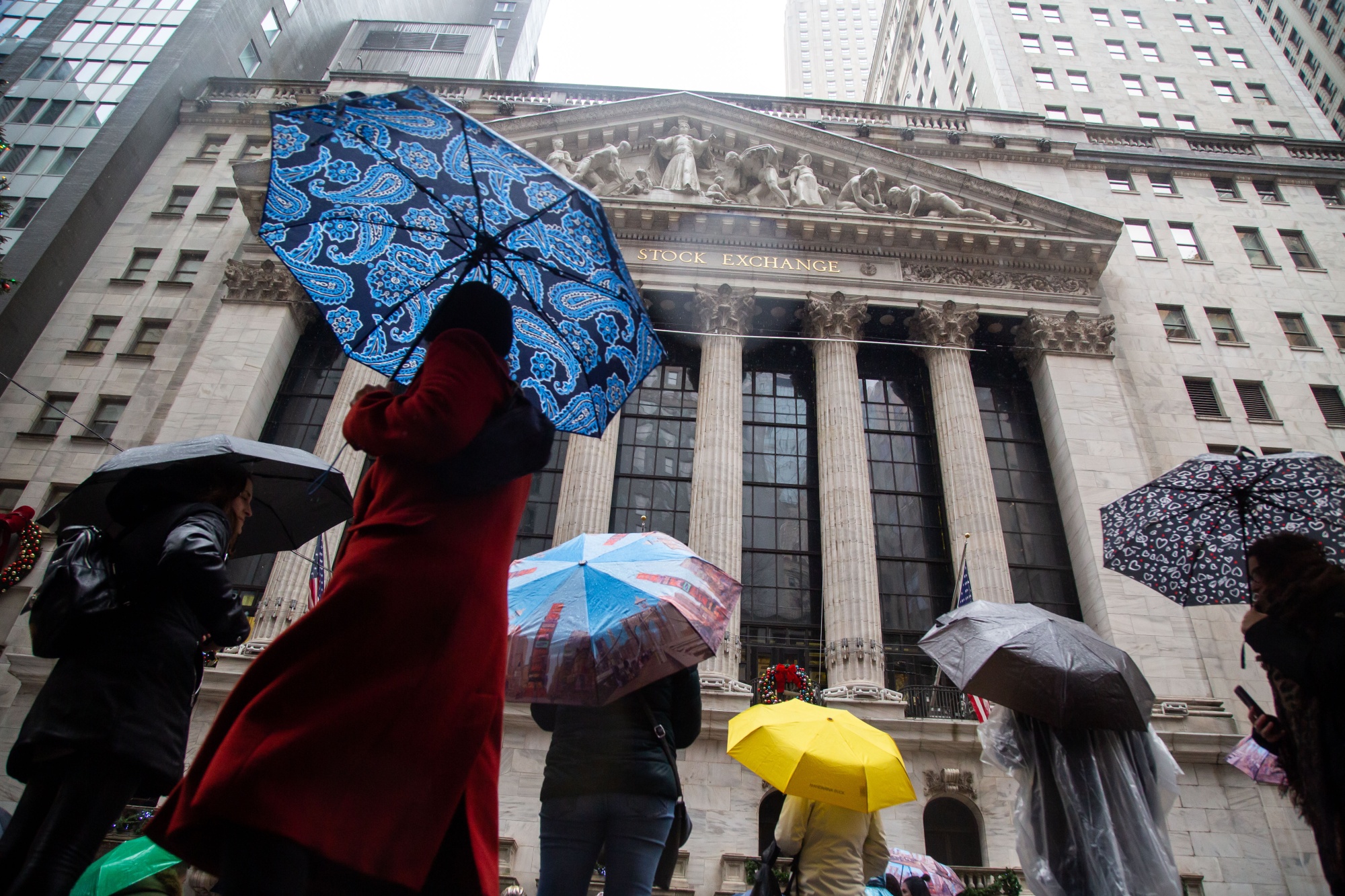 Pedestrians pass in front of the New York Stock Exchange on Jan. 3. US stocks fell Tuesday as losses in Apple&nbsp;and Tesla weighed on the S&amp;P 500 and the tech-heavy Nasdaq 100.