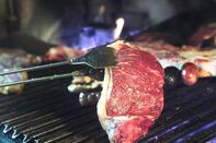 A steak of Argentine beef is put on the grill of a