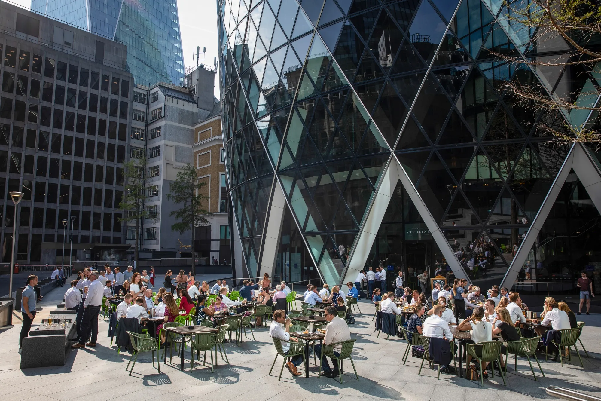 Customers sit at tables at a restaurant outside 30 St. Mary’s Axe in the City of London, on Sept. 15.