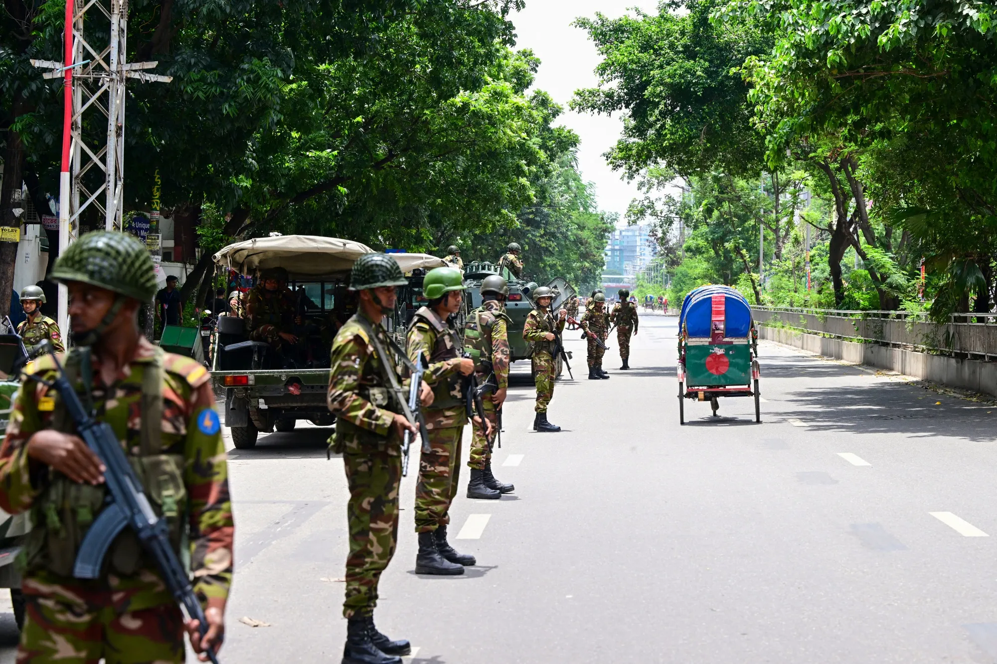 Soldiers stand guard along a street during a curfew&nbsp;in Dhaka on July 23.