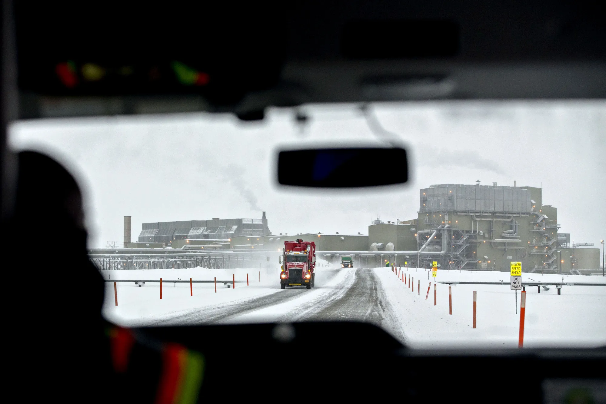 Trucks travel near an oil processing facility in Prudhoe Bay, Alaska.