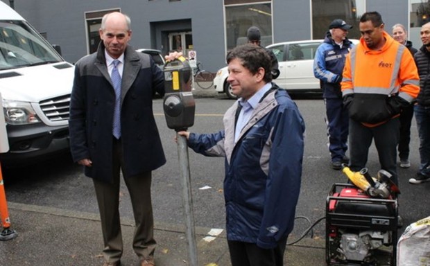 Portland City Commissioner Steve Novick, right, gives Portland's last single-space parking meter to Oregon Historical Society director Kerry Tymchuk.