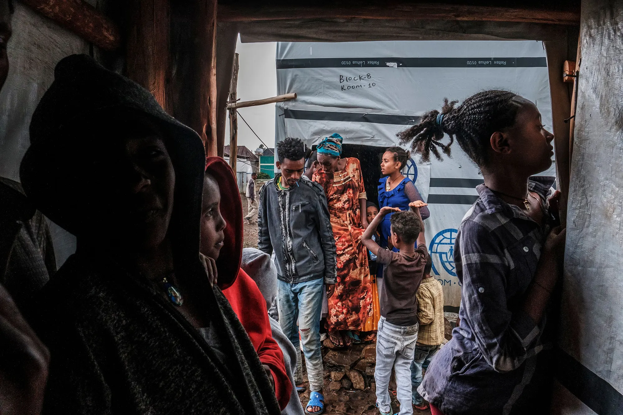 Internally displaced people protect themselves from the rain at a camp in the town of Azezo, Ethiopia, on July 12.&nbsp;