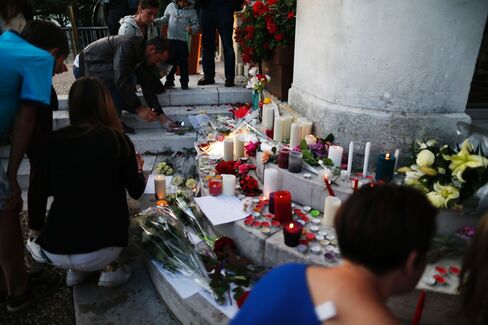 People pay tribute to the slain priest on July 26.