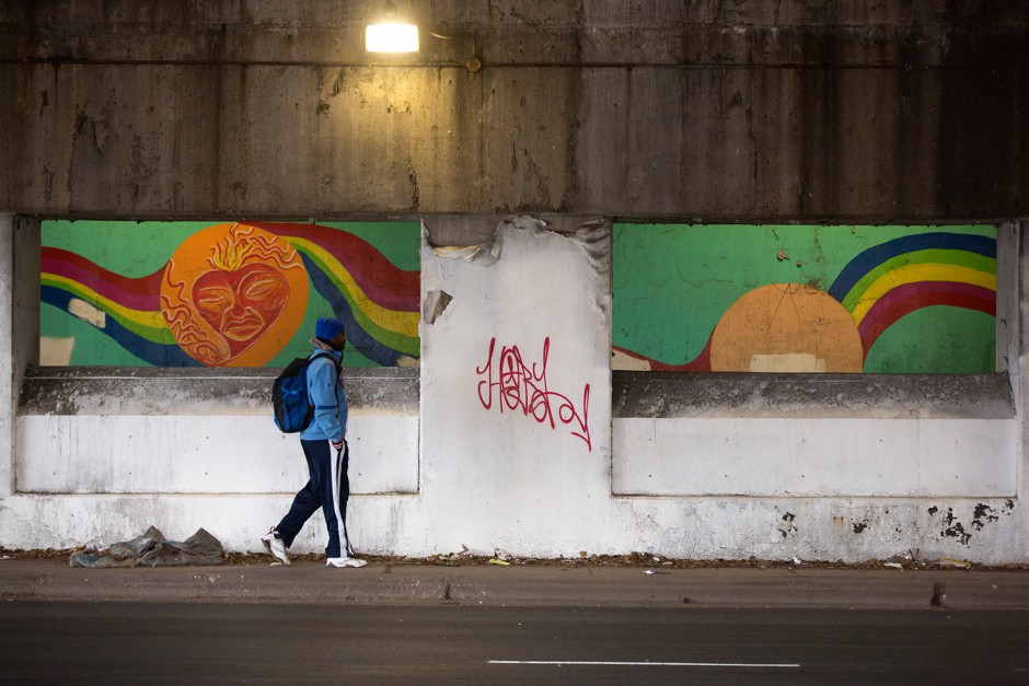 A man walks under an overpass and by concrete barriers installed to deter homeless camping in Avondale, Chicago. 
