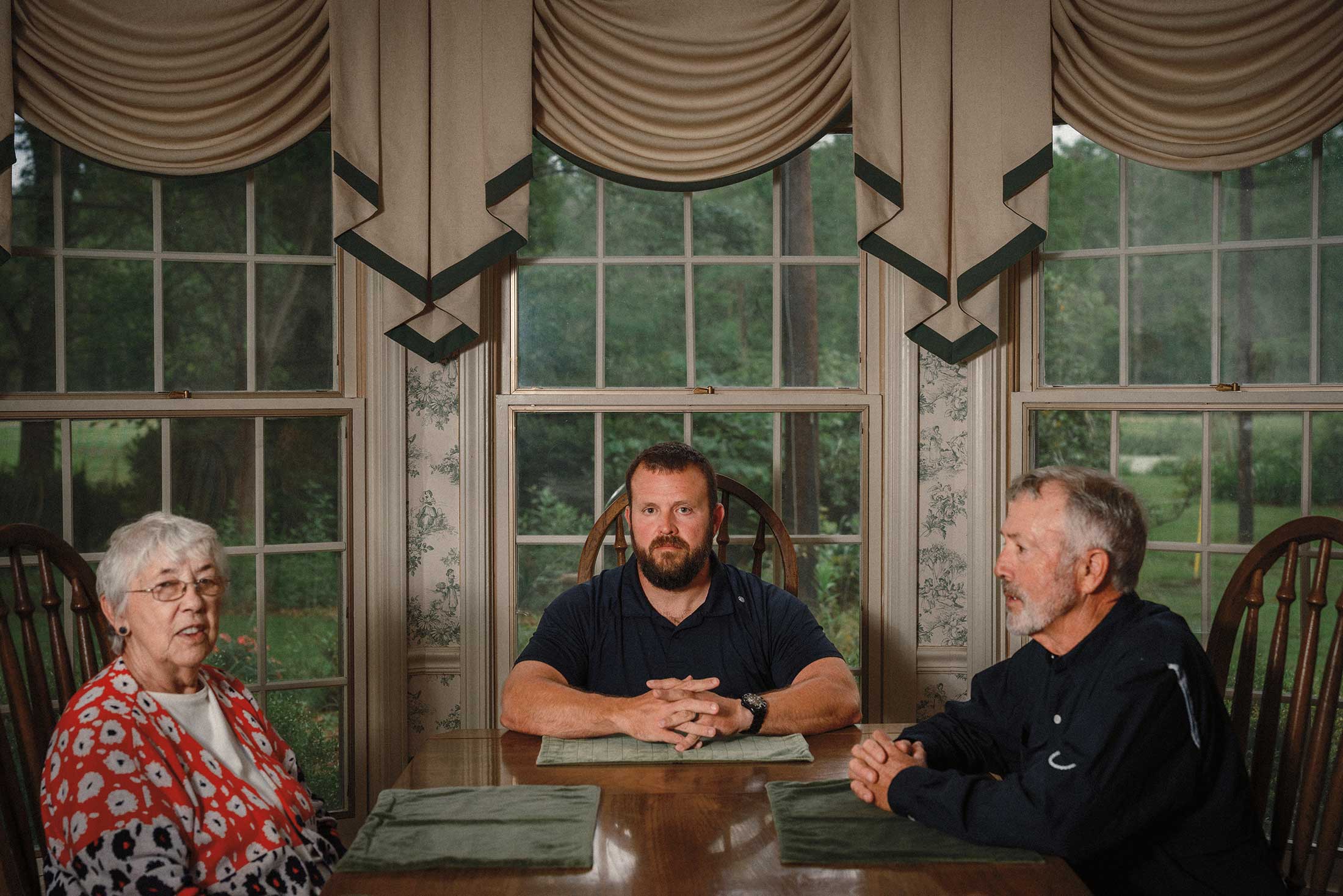 Ann, Dustin and Todd Morris at her home, all seated at the table where she plays host to weekly dinners that can draw dozens of family members.