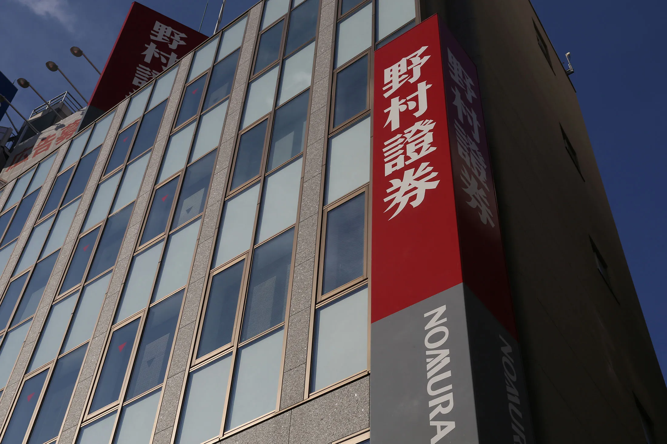 Signage for Nomura Securities Co., a unit of Nomura Holdings Inc., is displayed outside a branch in Tokyo, Japan, on Wednesday, Nov. 30, 2016. A recovery in Nomura's businesses outside of Japan is continuing in the current quarter, Nomura Chief Executive Officer Koji Nagai said at an investor forum today.
