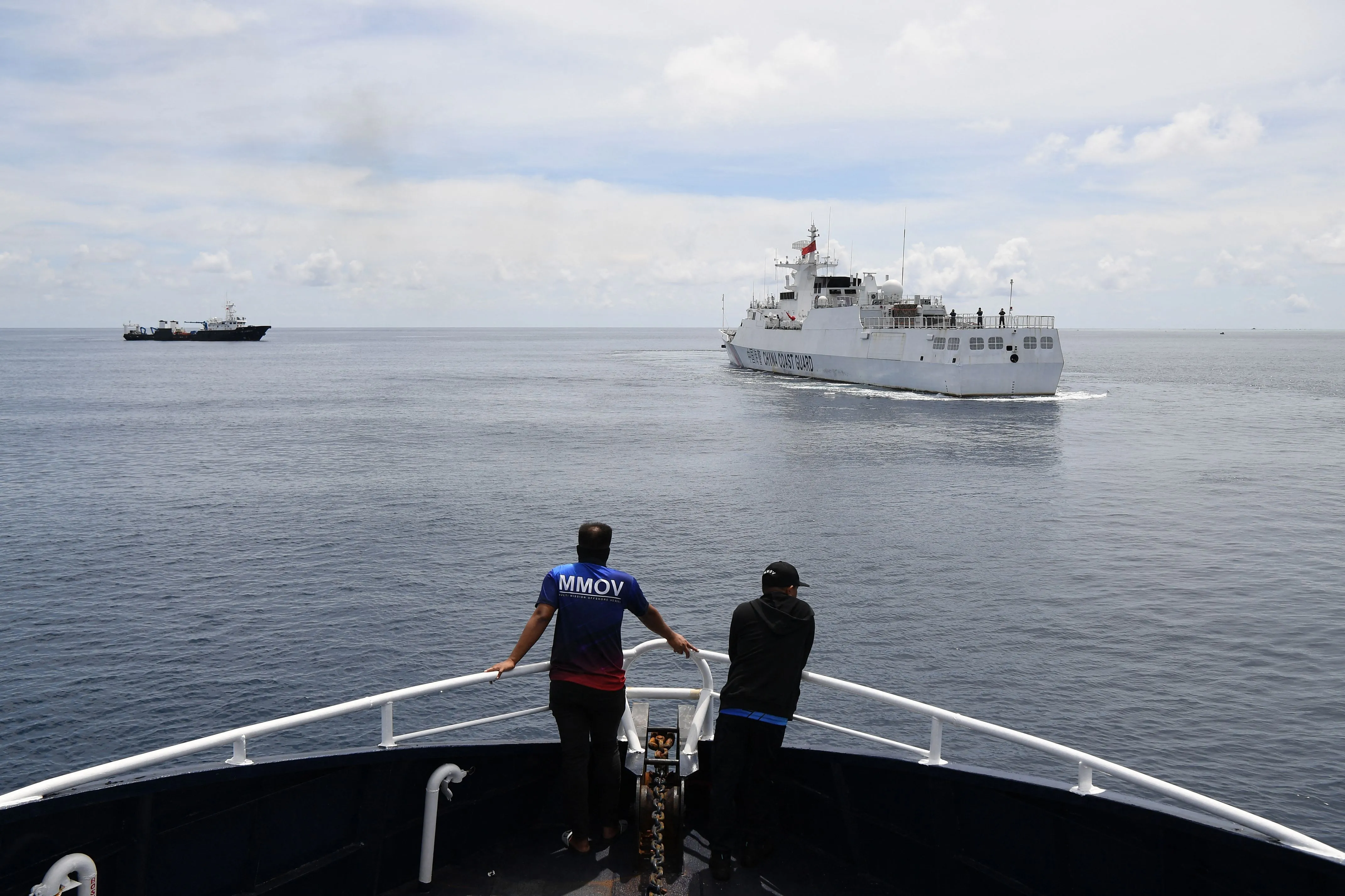 Personnel on board Philippine Bureau of Fisheries and Aquatic Resources (BFAR) ship monitor a Chinese coast guard, right, ship near the entrance of Chinese-controlled Scarborough Shoal on Sept. 22. 