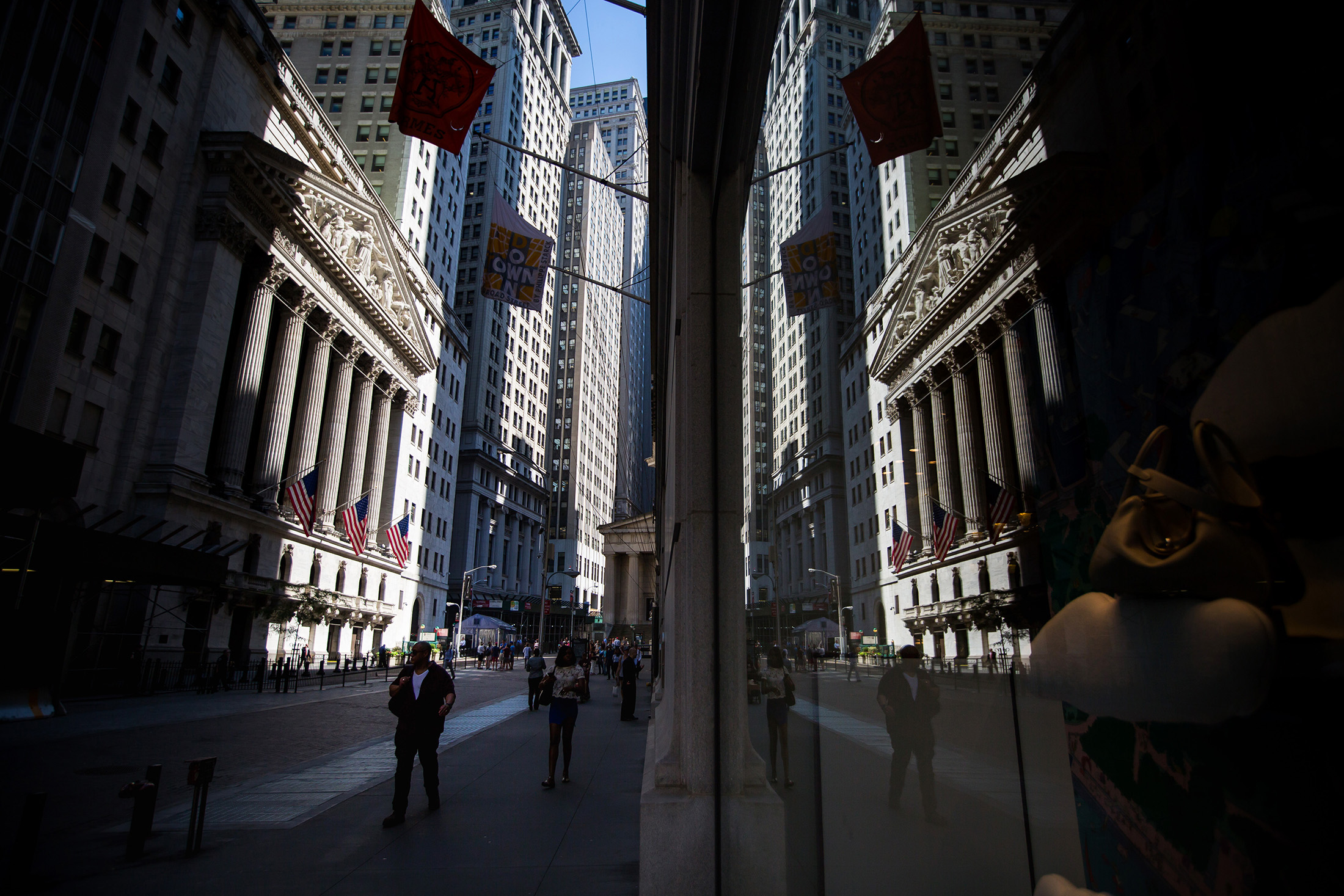 Pedestrians walk past the New York Stock Exchange.
