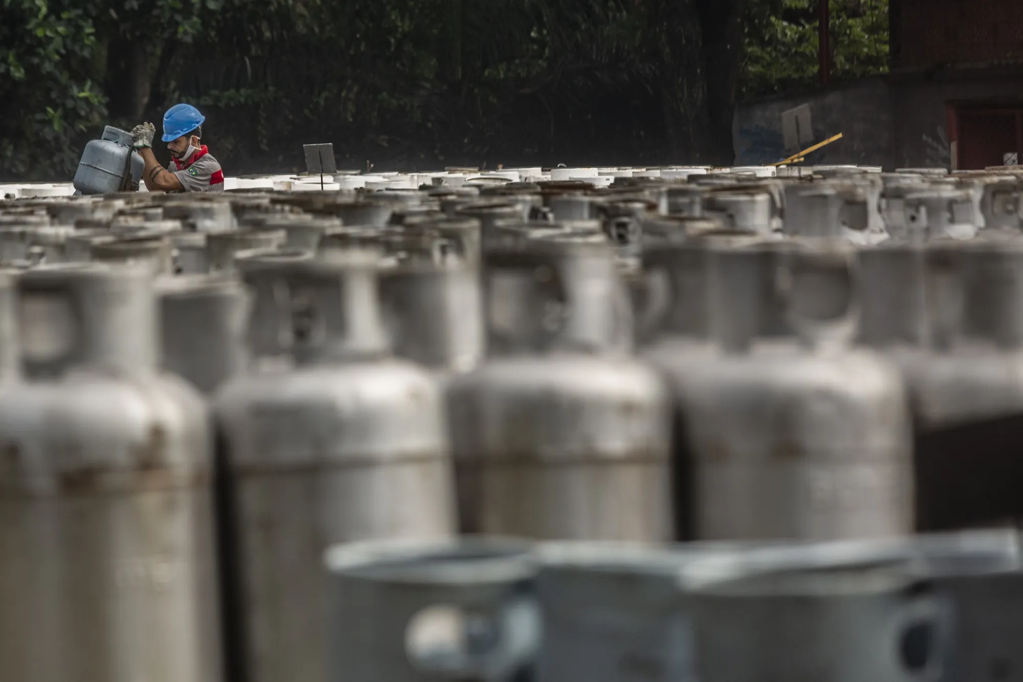 A worker organizes cooking gas canisters near a Petrobras refinery in Duque de Caxias,&nbsp;Brazil.&nbsp;