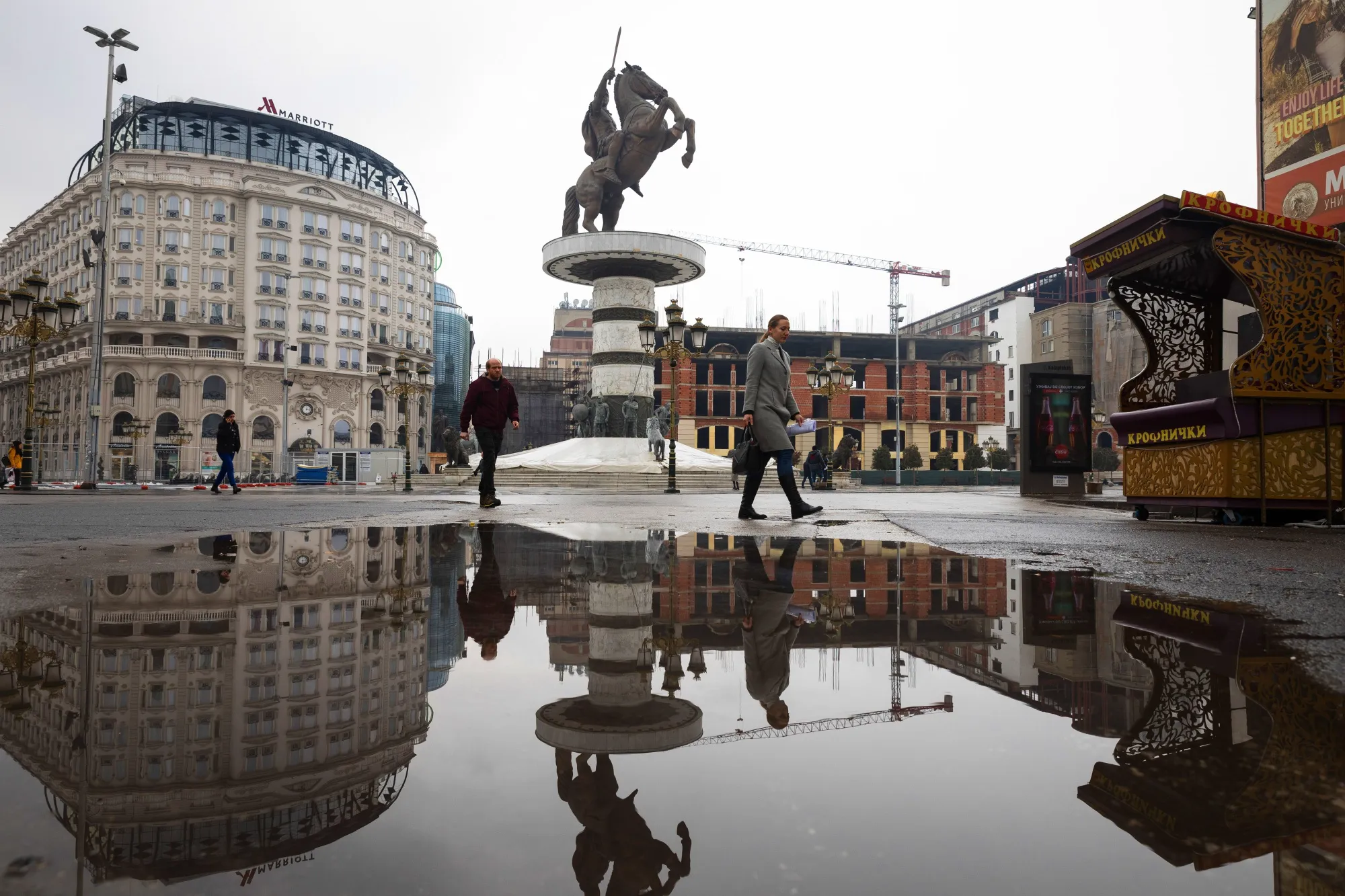 The "Warrior on the Horse" statue sits in a puddle reflection in central Skopje, North Macedonia.