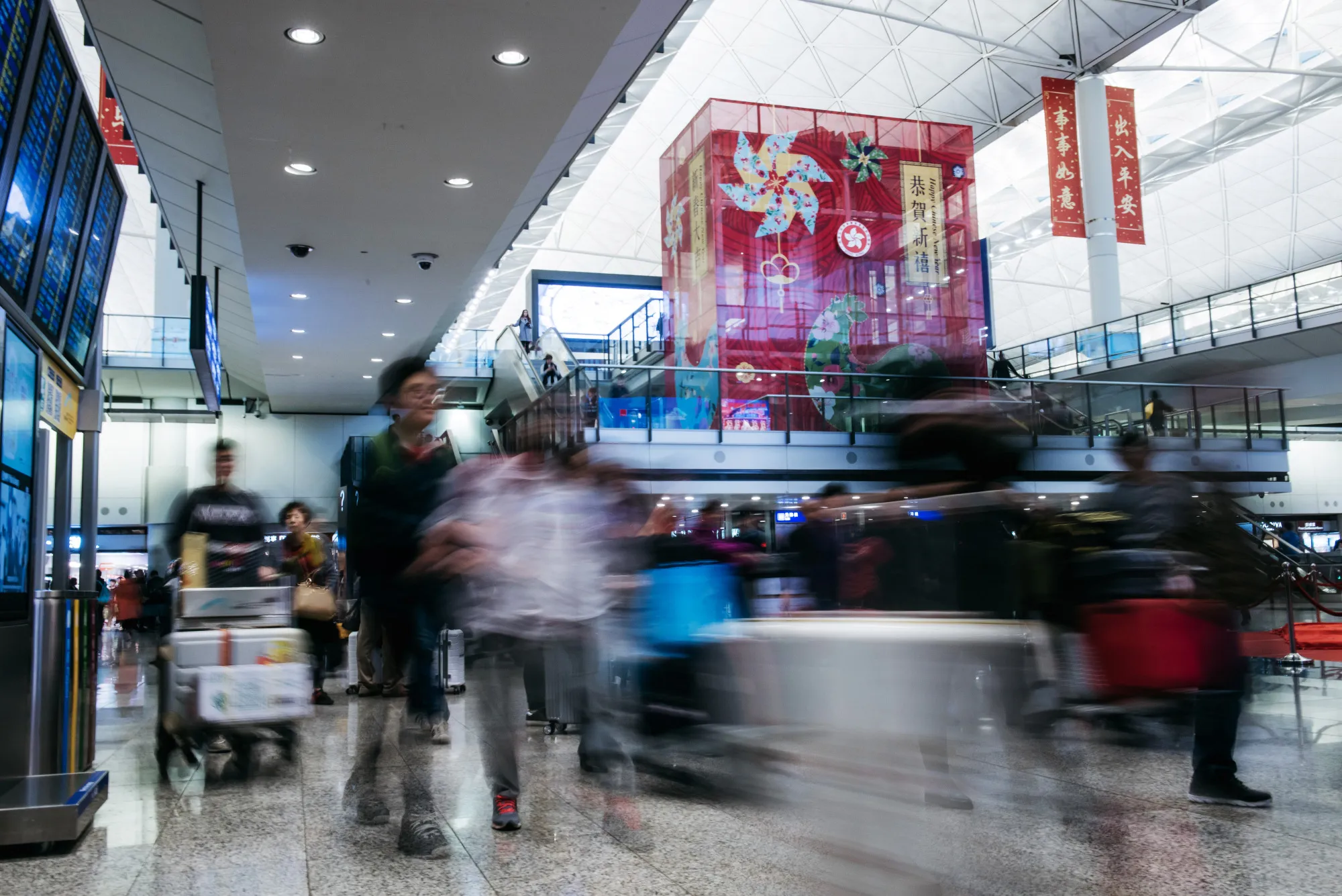 Travelers walk through the arrival hall at Hong Kong International Airport in Hong Kong, China.