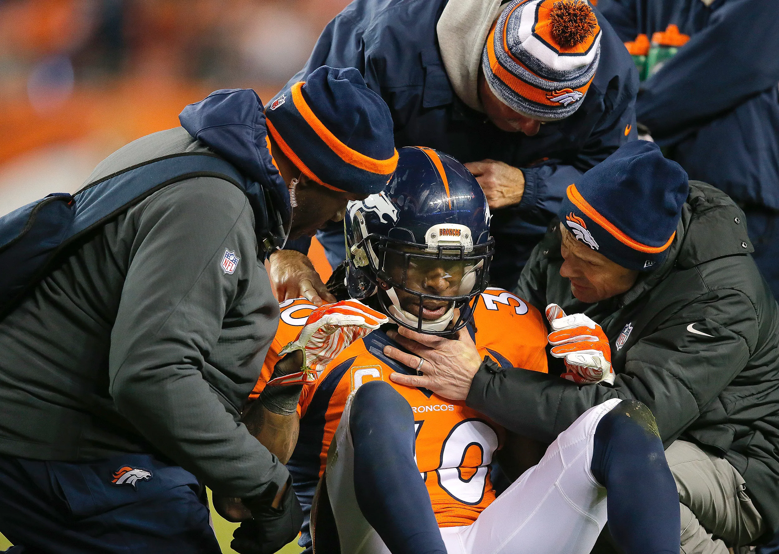 Strong safety David Bruton #30 of the Denver Broncos is attended to by trainers after a play that would force him out of the game with a reported concussion during a game against the Oakland Raiders at Sports Authority Field at Mile High on Dec. 28, 2014.
