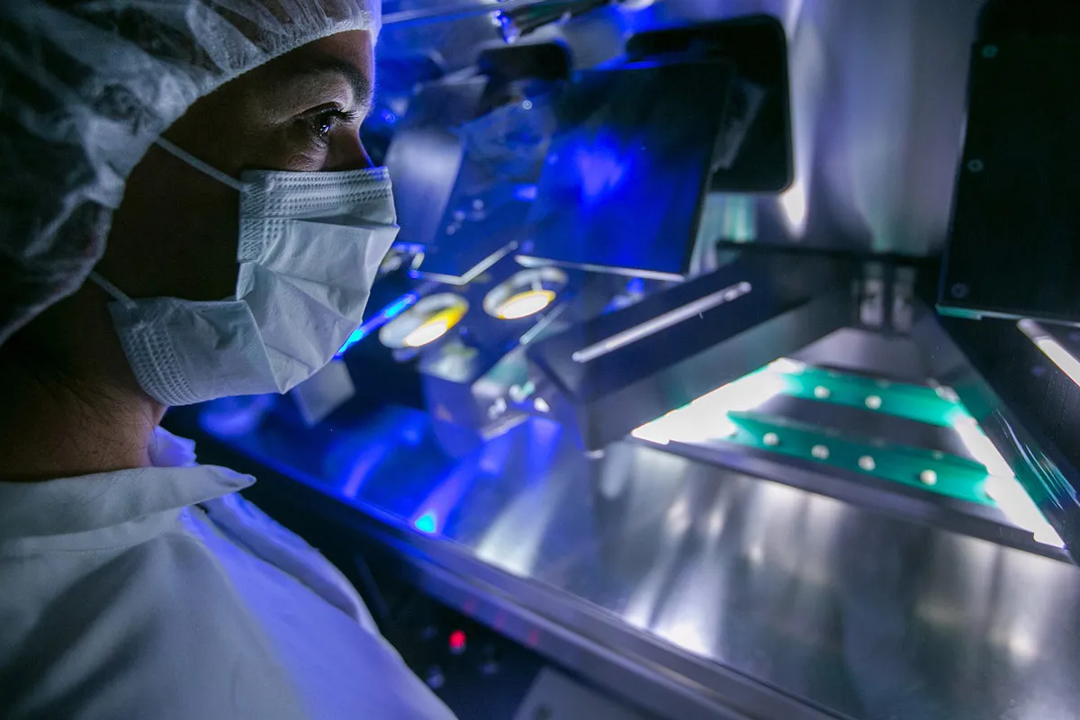 A laboratory technician watches as a machine checks blood pressure tablets for any imperfections in the laboratories at the Merck KGaA headquarters in Darmstadt, Germany.
