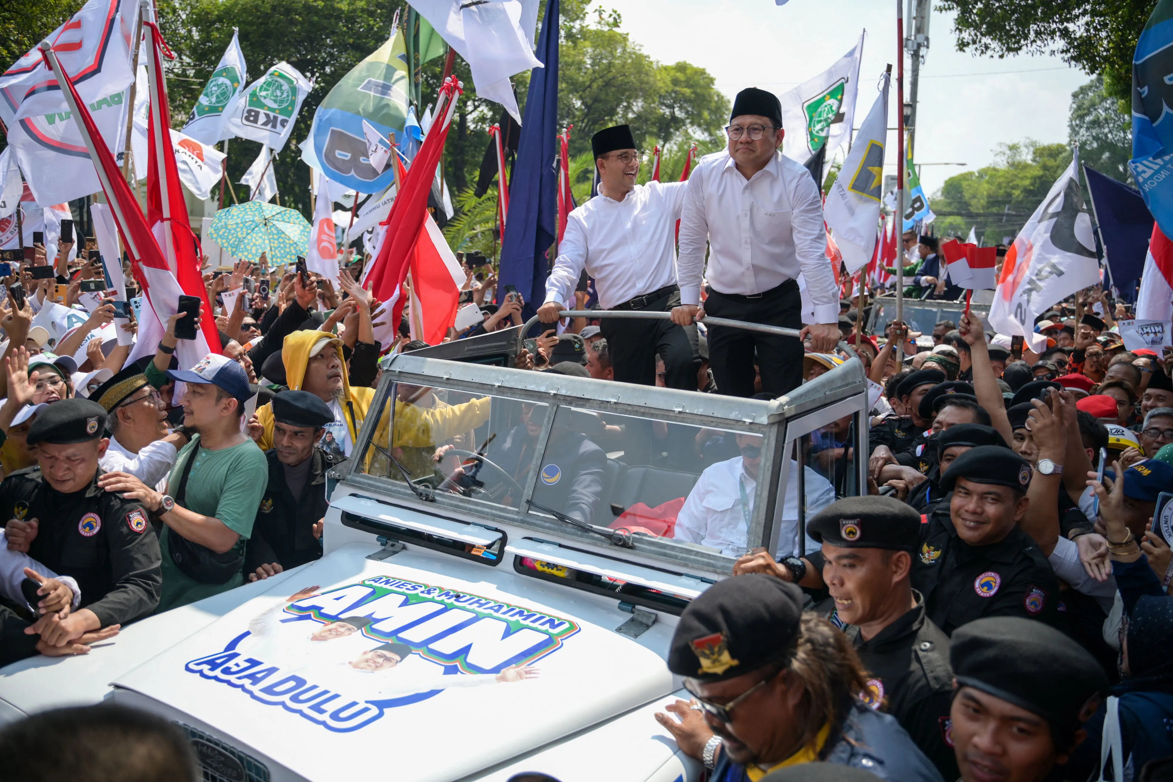 Anies Baswedan, left, and Muhaimin Iskandar greet supporters gathered in Jakarta on Oct. 19.
