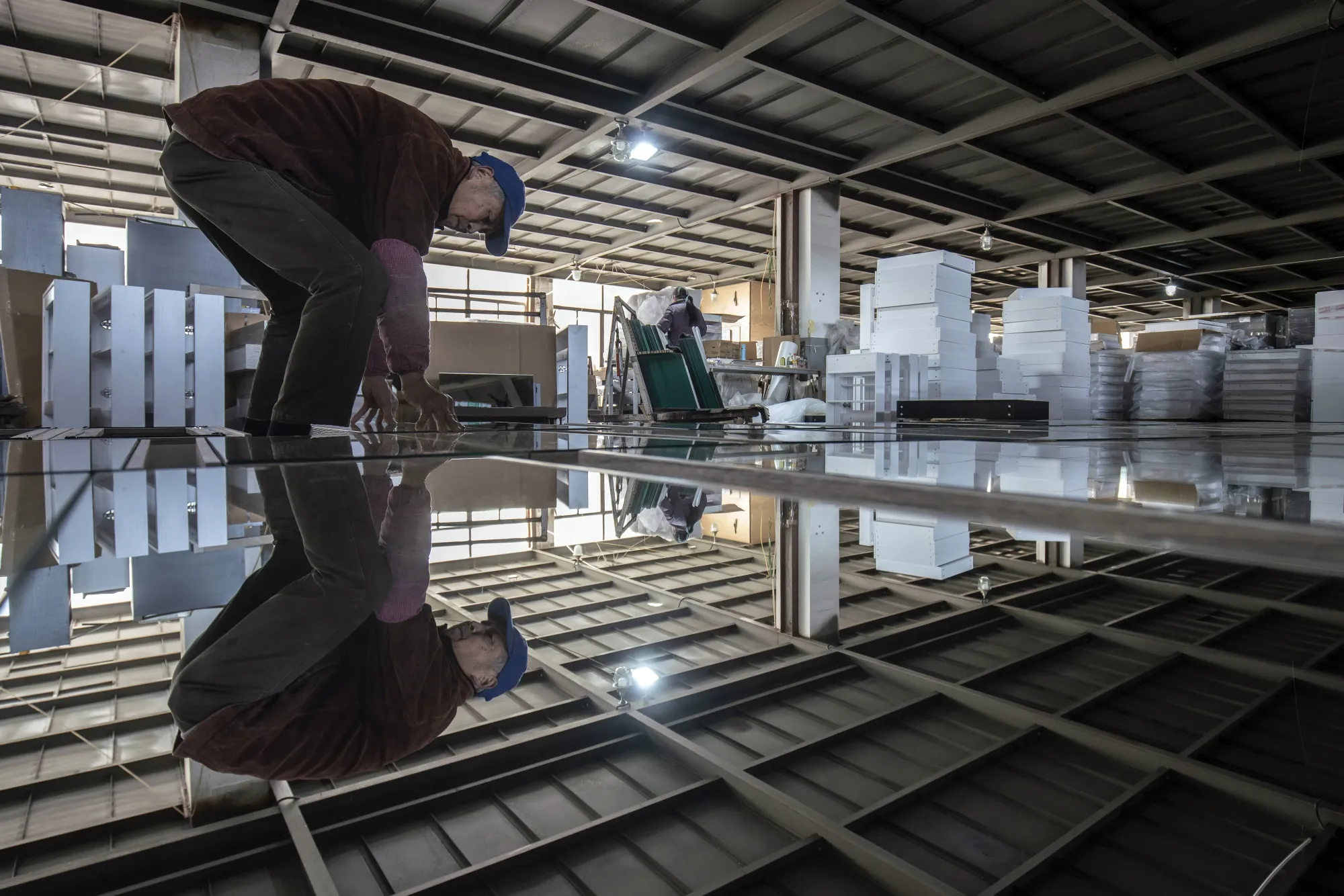 A worker assemble mirrors on cabinets at the Dicheng Technology factory in Hangzhou, China.