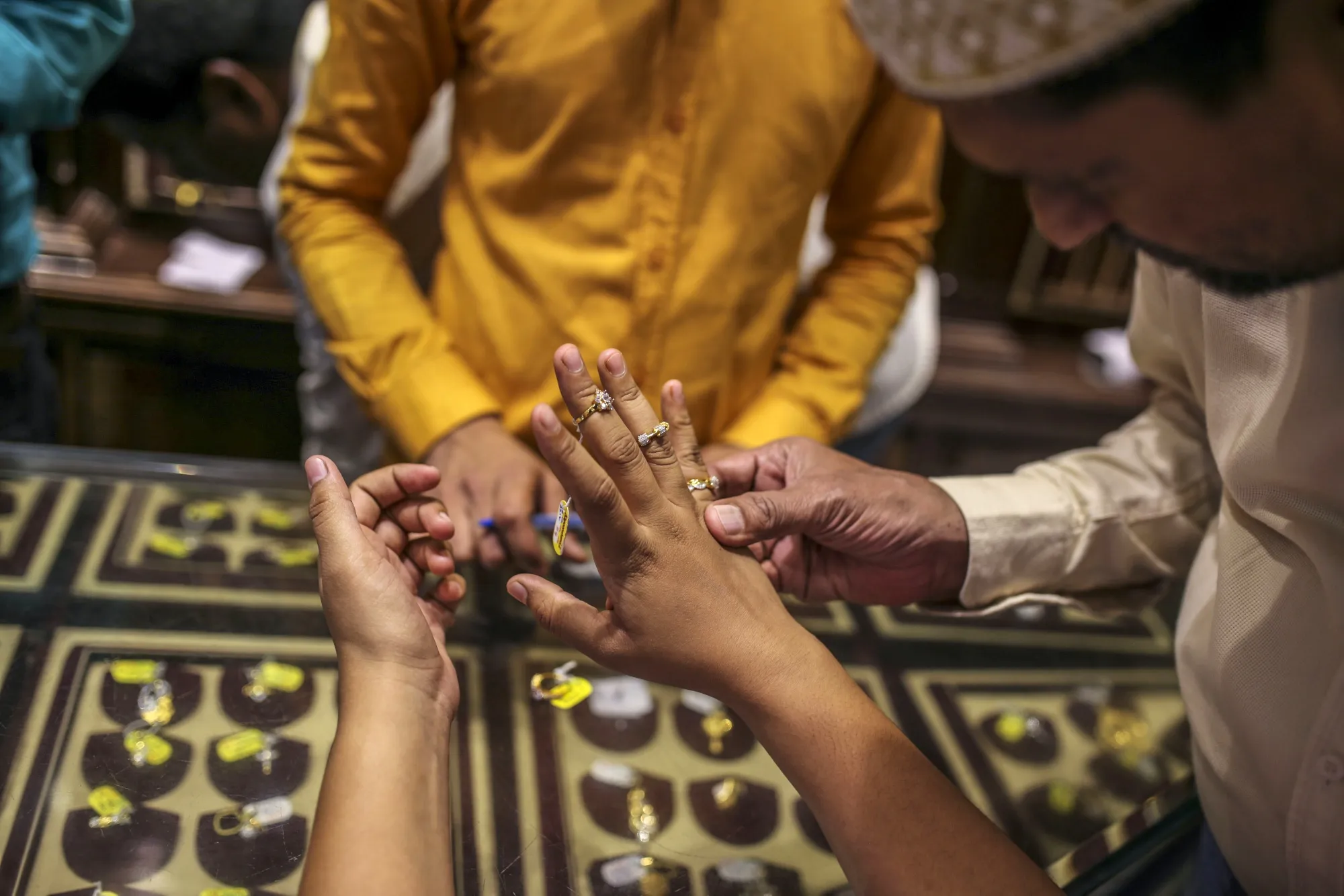 A customer tries on gold rings inside a&nbsp;jewelry store&nbsp;in Mumbai.