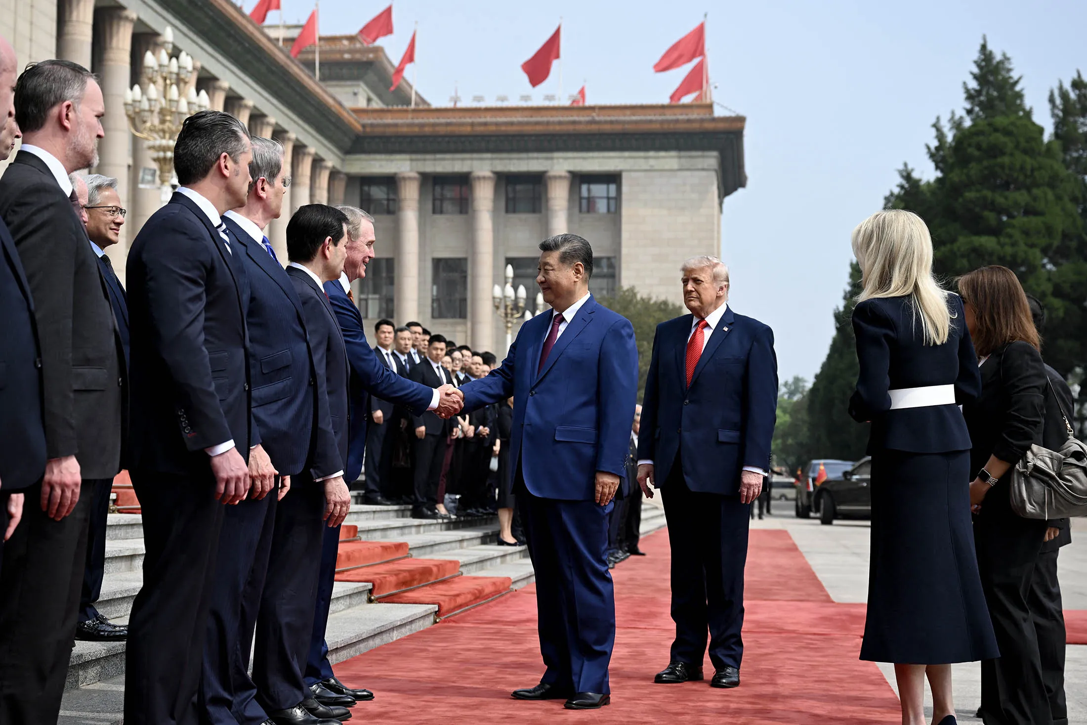 President Xi Jinping shakes hands with members of the US delegation next to President Donald Trump during a welcome ceremony at the Great Hall of the People in Beijing on May 14.