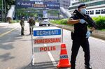 Members of the Malaysian Army and a police officer man a checkpoint during lockdown&nbsp;in Kuala Lumpur, Malaysia.