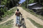 A man pushes a bicycle along a track in a village of Nalbari district, Assam, India on Sep. 1.