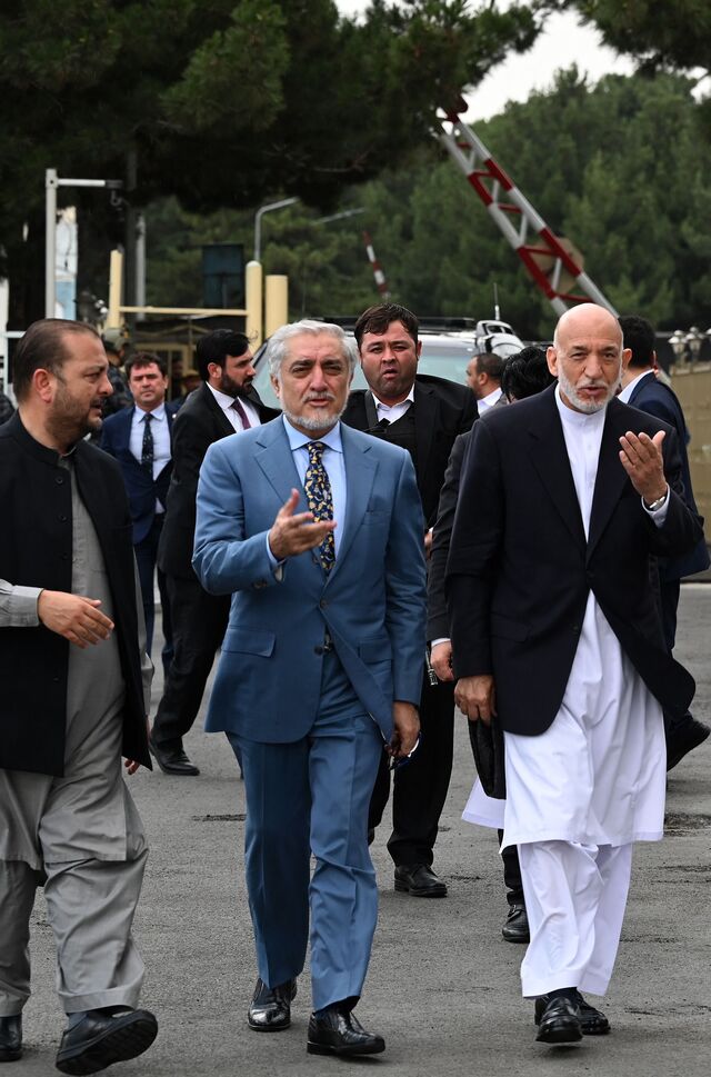Former Afghan President Hamid Karzai (R) walks next to Chairman of the High Council for National Reconciliation Abdullah Abdullah (C) as they arrive to address a press conference at Hamid Karzai International Airport in Kabul on July 16, 2021.