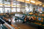 People rest on the Staten Island Ferry as temperatures reach into the 90s in New York on July 21.