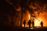 Firefighters search the perimeter of a building at the Soda Rock Vineyards during the Kincade fire in Healdsburg, California on Oct. 27.