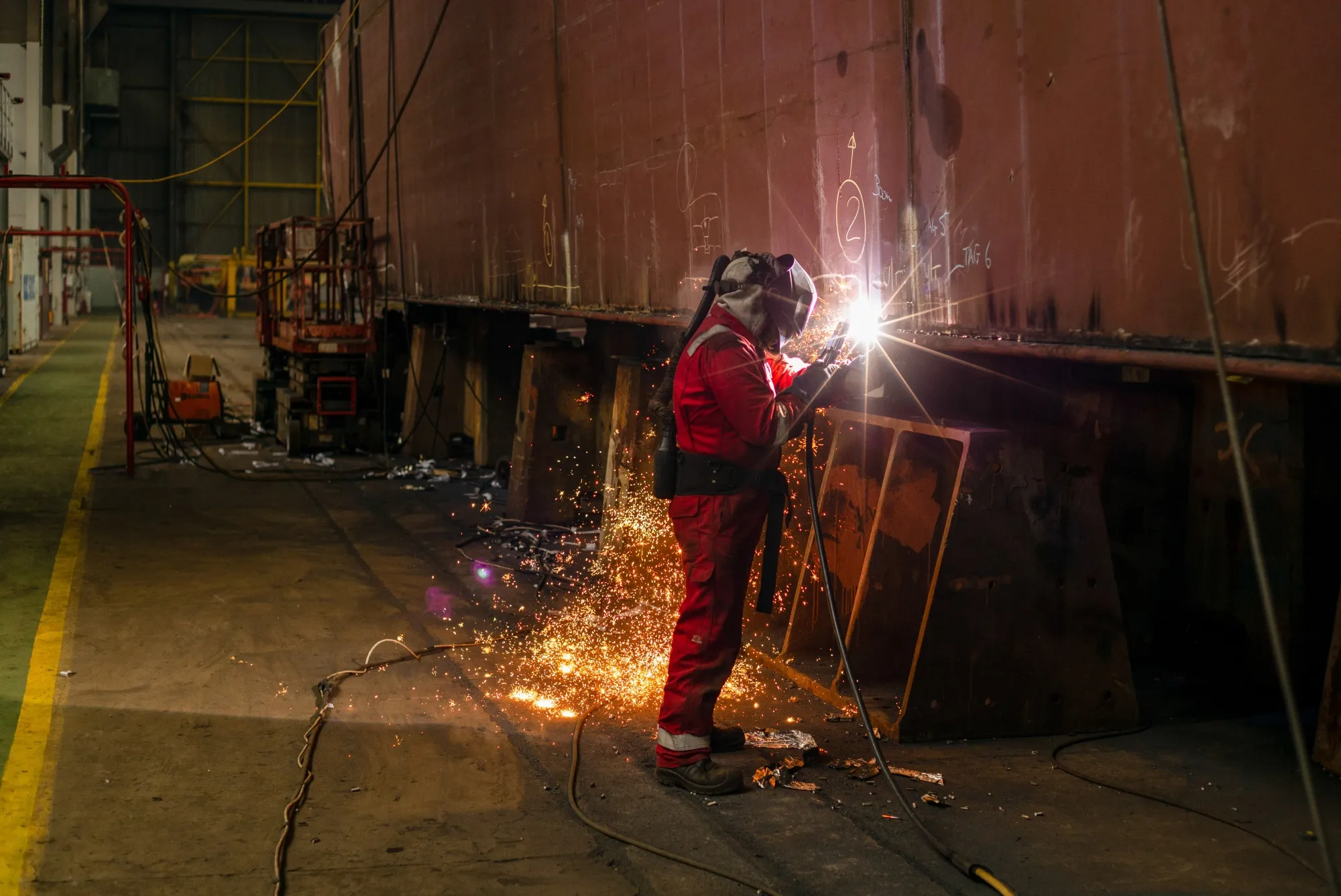 A welder works on a barge under construction in Belfast