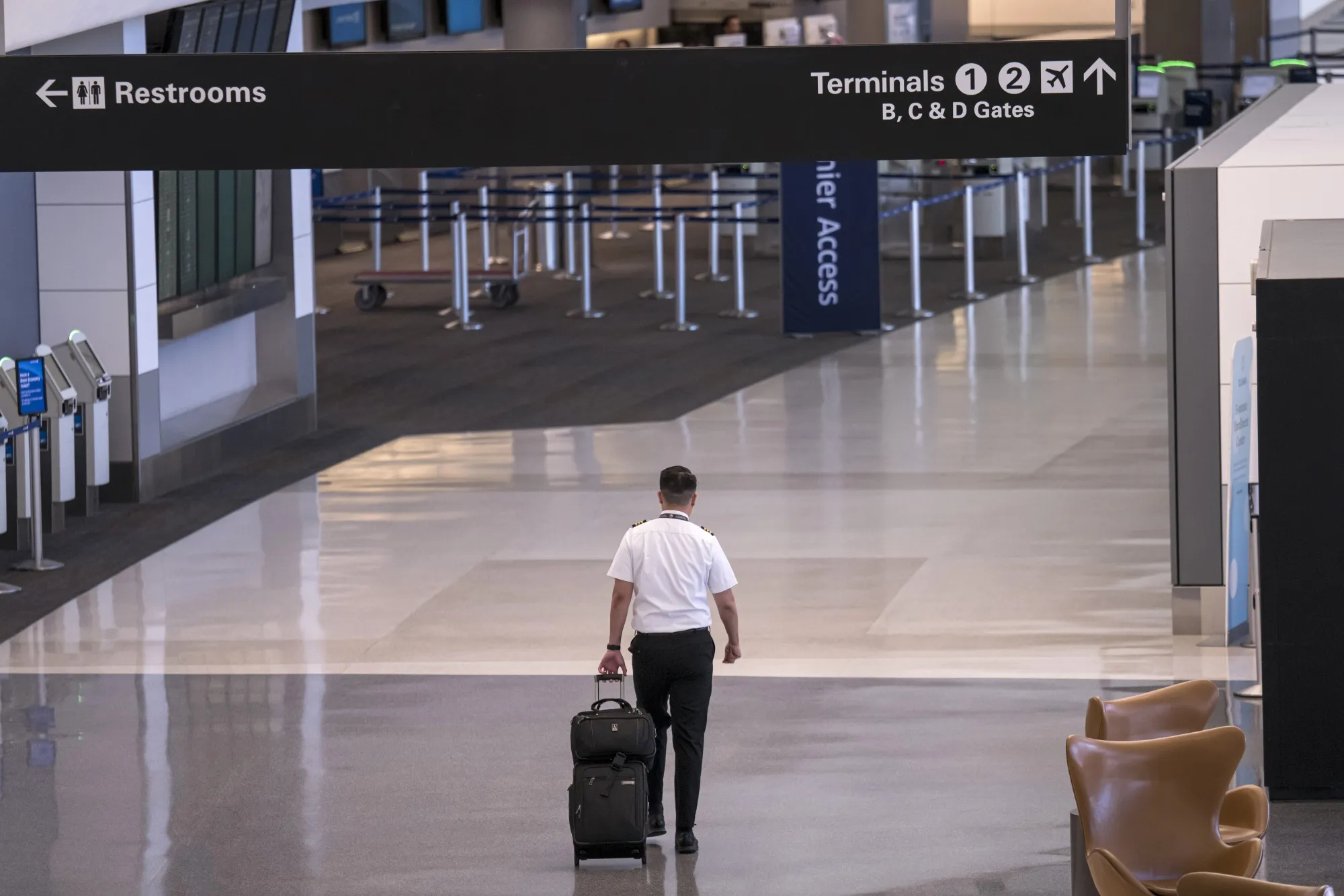 A pilot pulls luggage while walking through a terminal at San Francisco International Airport, on April 2.
