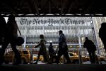 Pedestrians pass in front of the New York Times building in New York.