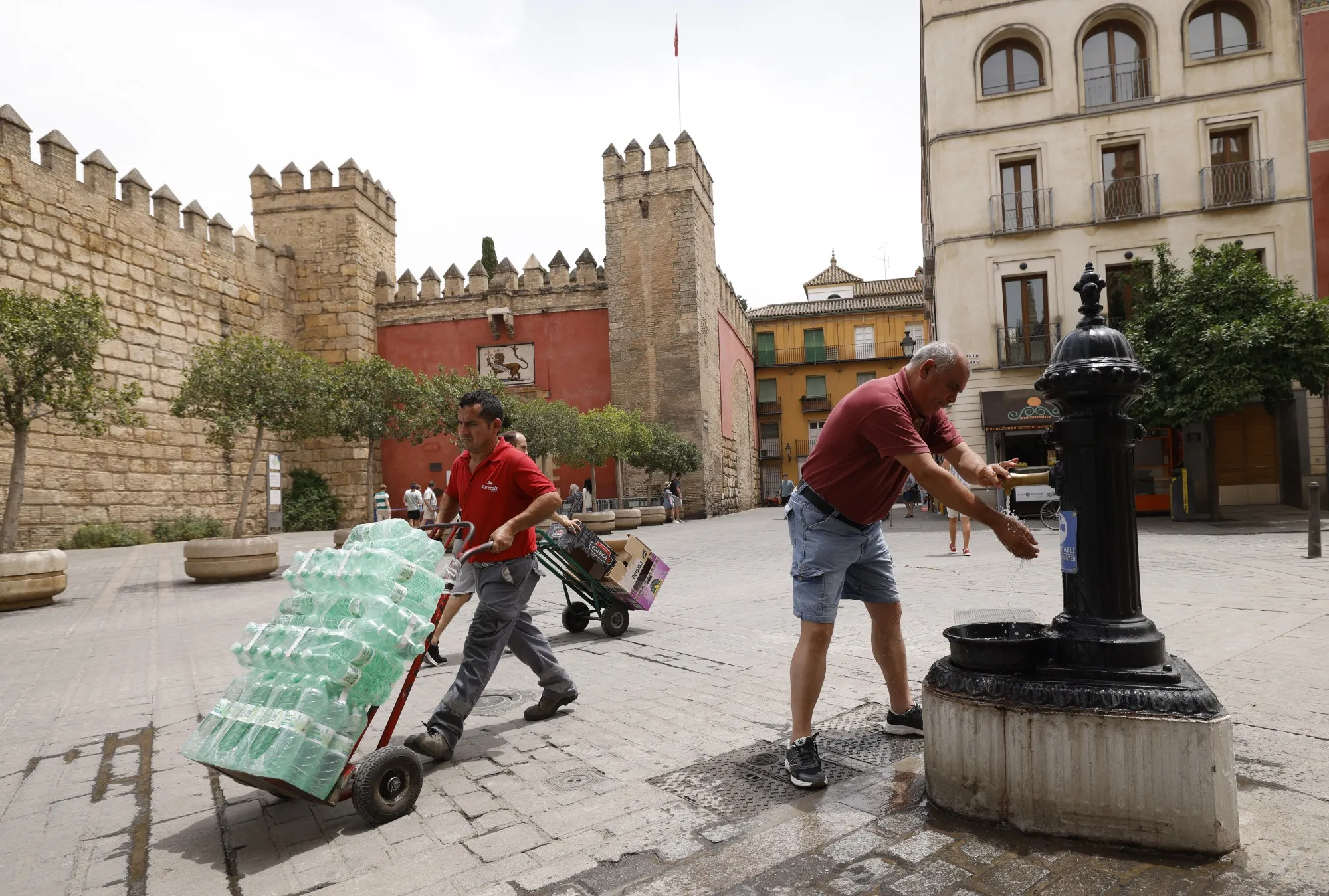 A pedestrian cools himself at a public fountain during a heat wave in Seville, in June.&nbsp;