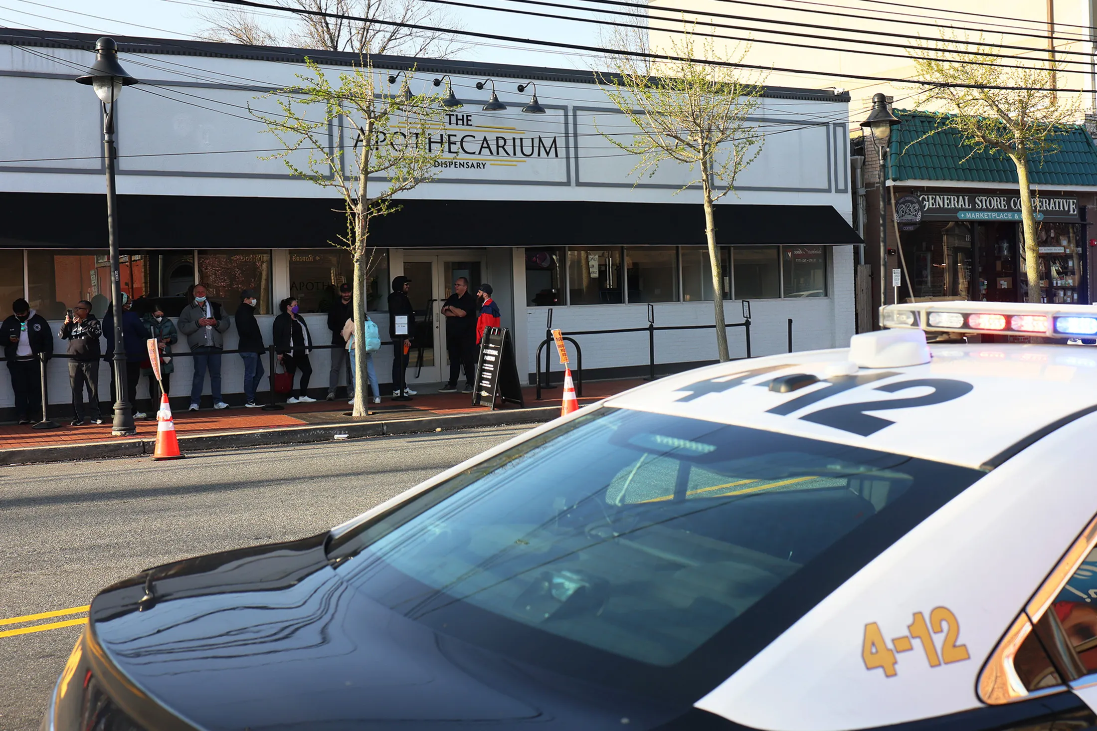 A police vehicle sits outside a cannabis dispensary as residents wait to enter on the first day of recreational sales in Maplewood, New Jersey.