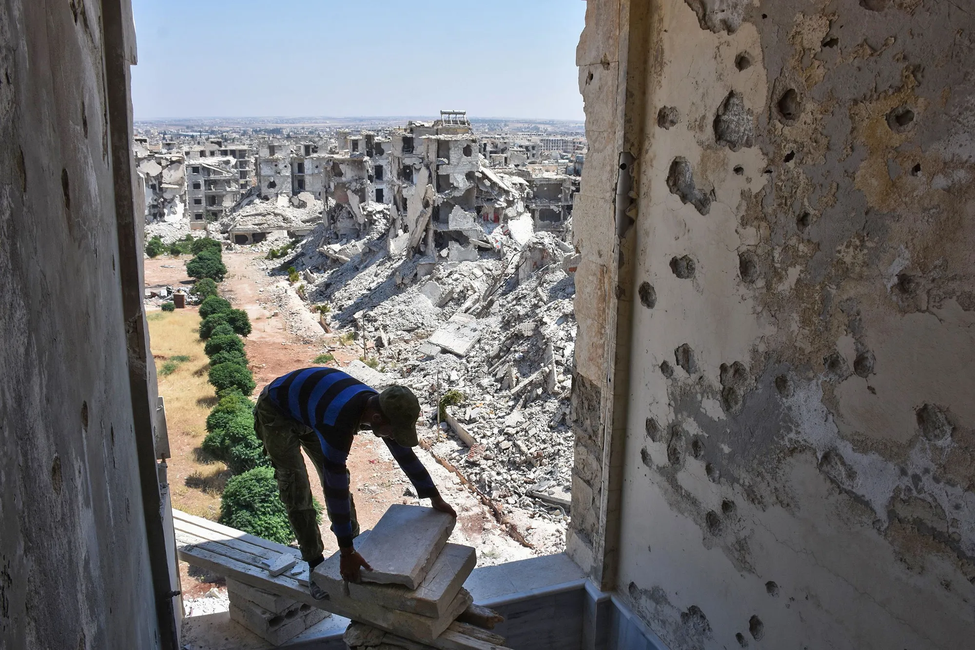 A man&nbsp;works as residents reconstruct their damaged homes in the al-Zahraa neighborhood of Aleppo&nbsp;on July 6.
