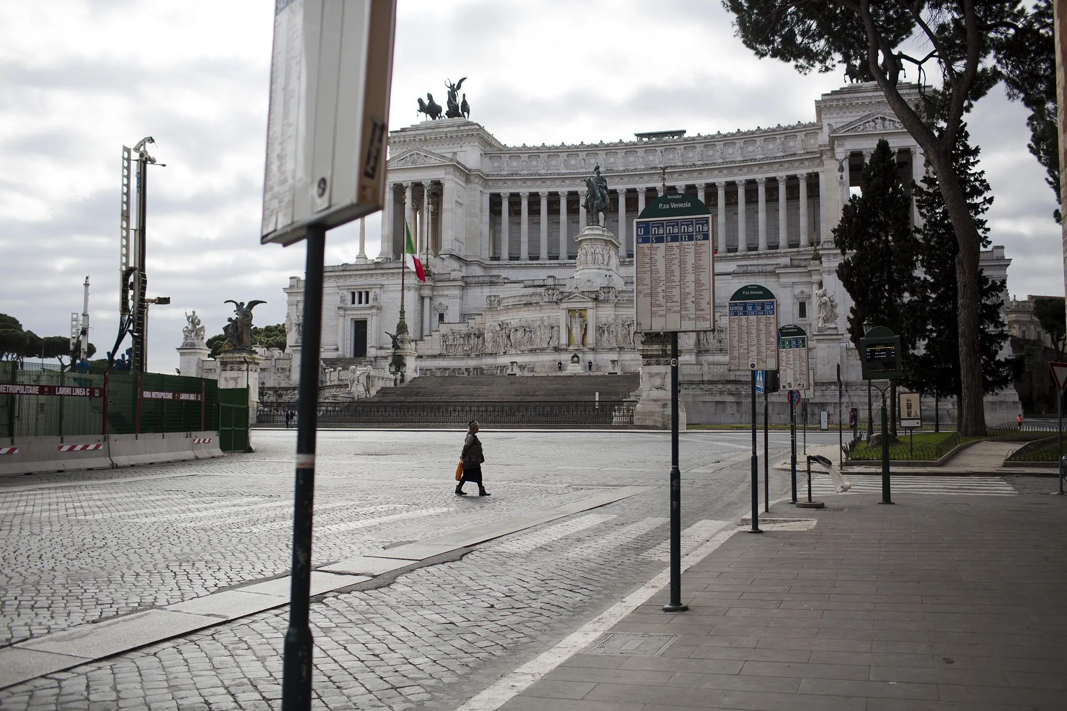 A woman walks in an empty Piazza Venezia as Italian government continues restrictive movement measures to combat the coronavirus outbreak in Rome, on March 15.